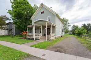 A two-story house with a porch and a small attached garage.