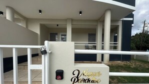 A gated entrance to a building with a sign that reads "Negue's Boutique." - Paradise Beach Apartment Vieques 3 (Vieques)