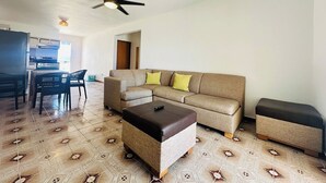 A living room with a sofa, ottoman, and a ceiling fan. - Paradise Beach Apartment Vieques 3 (Vieques)