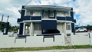 A modern two-story house with a flat roof, a balcony, and a gated entrance. - Paradise Beach Apartment Vieques 5 (Vieques)