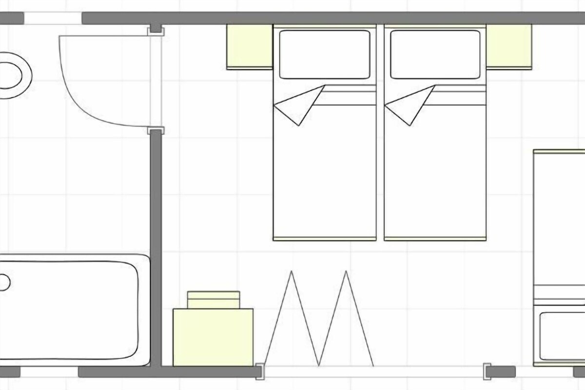 A hotel room layout with a bed, a desk, a chair, a wardrobe, and a bathroom.