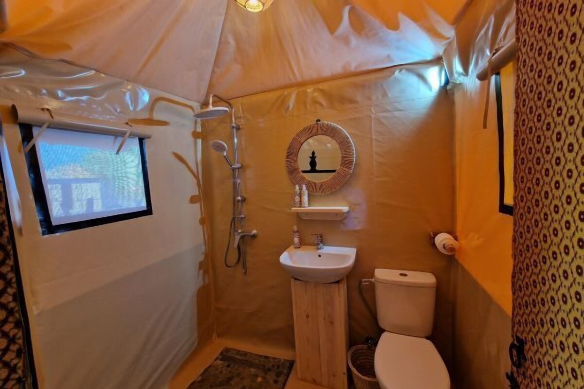 Une petite salle de bain de camping, comprenant des toilettes, un lavabo et une douche.