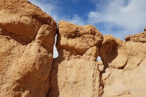 A natural rock formation with a narrow gap between two large rock faces. - Nkhila Lodge (Sidi Badhaj)