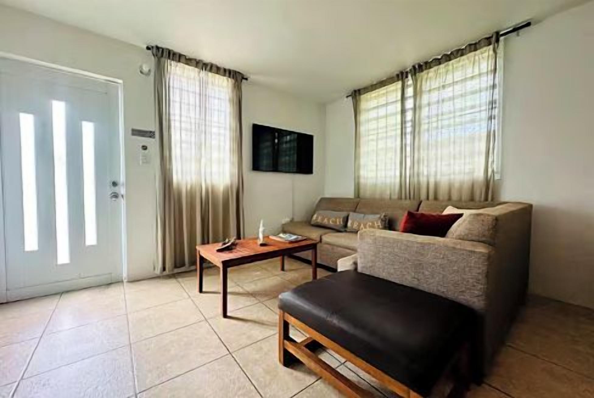 Una sala de estar con un sofá, una mesa de centro y una puerta.