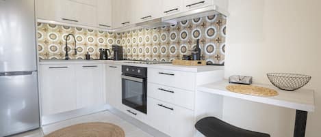Enjoy cooking in this kitchen with sleek cabinetry, a stainless steel refrigerator, and a black oven.