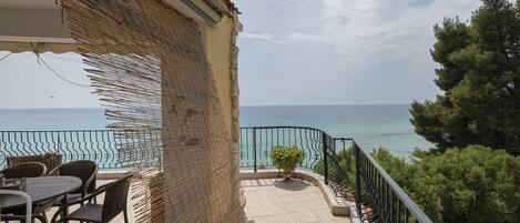 Enjoy breathtaking sea views from this balcony with a table and chairs.