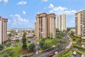 A high-rise residential building with multiple floors, surrounded by greenery and a parking area. - Ocean View Walk to Mall Free Parking, W/D, AC (Aiea)