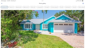 Une maison à deux étages avec un garage, entourée d’un jardin bien entretenu et d’une allée pavée.