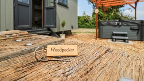 A wooden table with a keychain labeled "Woodpecker" and a metal bench in the background. - Woodpecker (Cambridge)