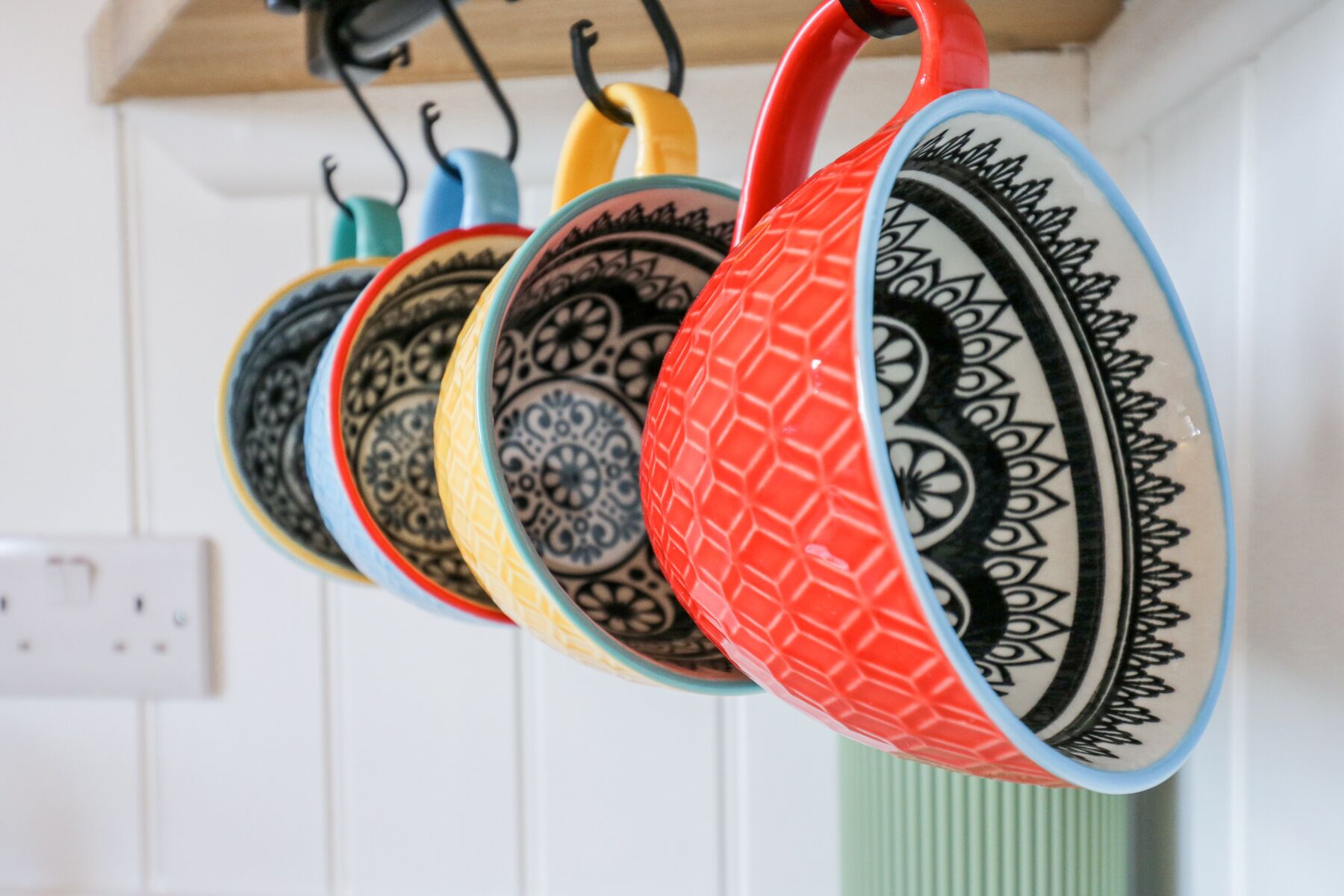 A row of colorful ceramic plates hanging on a wall.