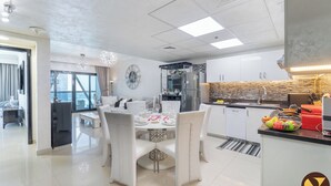 A modern kitchen with white cabinets, a stainless steel refrigerator, and a tiled backsplash. - Vogue| Park Tower DIFC near Museum of the Future (Dubai)