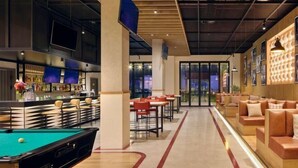 A modern lounge area with a pool table, bar, and seating. - Pinegrove Apartment (Durres)