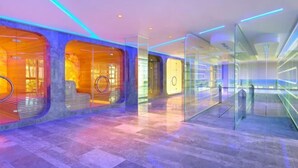 A modern interior with glass partitions, a central seating area, and a patterned floor. - Pinegrove Apartment (Durres)