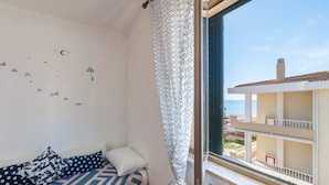 A balcony with a view of a building and the sea.