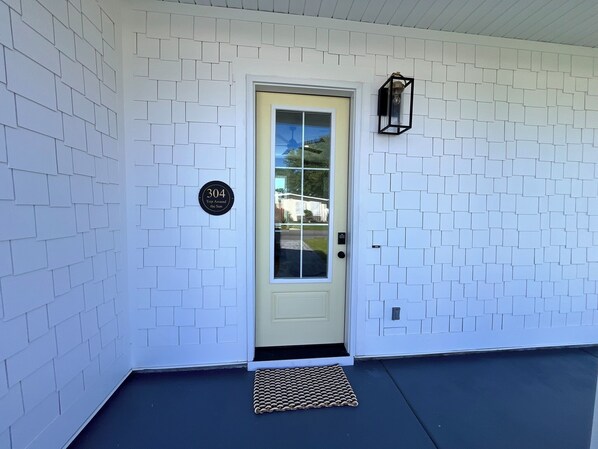 A white door with a glass panel, a mailbox, and a black lantern on the wall.