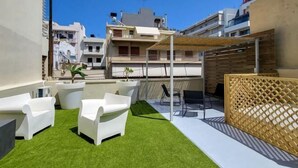 A rooftop patio with white outdoor furniture, artificial grass, and a wooden lattice fence. - Soneto 32 Heraklion House (Heraklion)