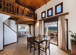 Un espace repas comprenant une table et des chaises, un canapé et une vue sur l’extérieur.