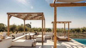 An outdoor patio with a pool, wooden pergolas, and seating areas. - Panagis Villa - Three Bedroom Villa, Sleeps 6 (Karavados)