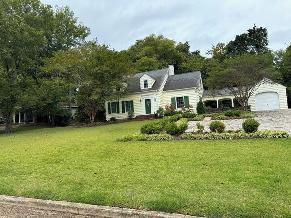 Una casa de dos pisos con un césped cuidado y un garaje.