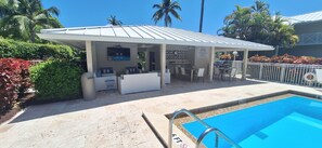 Un área de estar al aire libre cubierta con piscina, palmeras y un cartel que dice 'NO DIVING'.