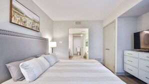 Un dormitorio con una cama grande, un televisor y un aparador.