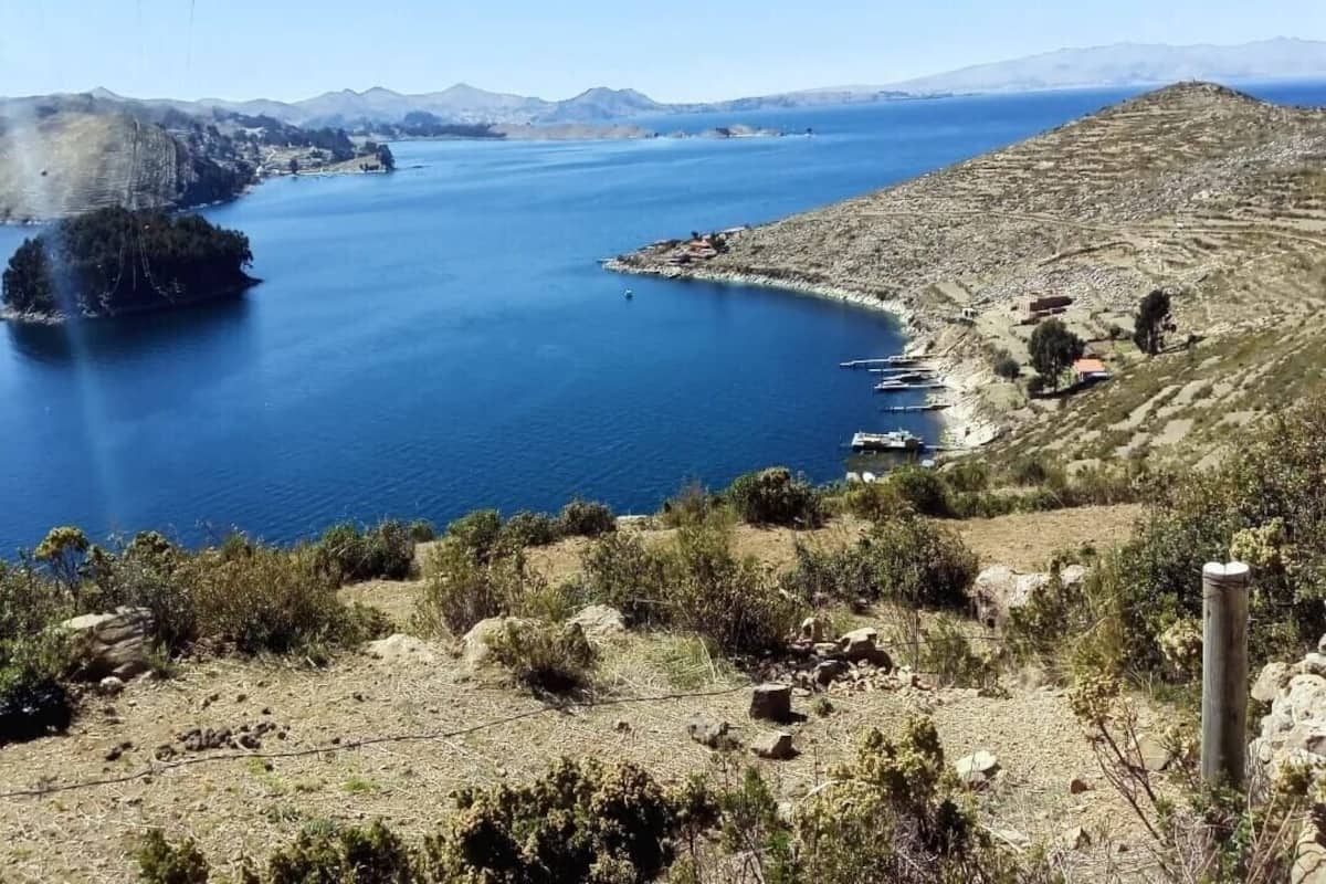 A coastal landscape with a large body of water, a small island, and a hilly terrain.