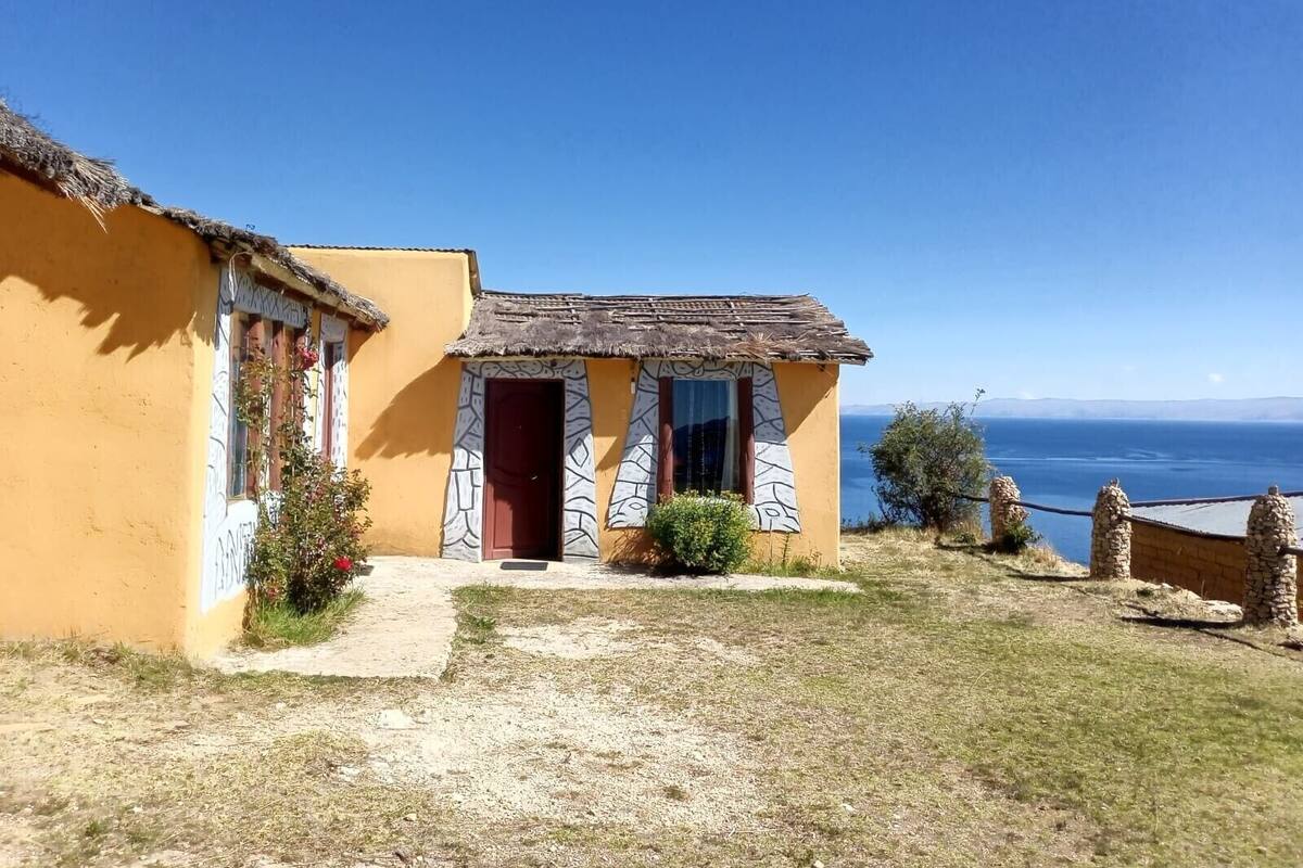 A coastal building with a thatched roof and a view of the sea.