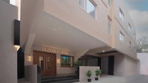 Een moderne hotelentree met een bord waarop “VICTORY STAY” staat.