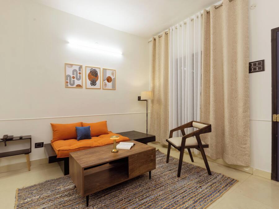 Una habitación con una cama, un escritorio, una silla, una lámpara y una puerta.