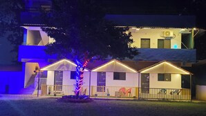 A building with multiple rooms, a staircase, and a tree with colorful lights. - SAAZ RESORT AND LAWN (Khalapur)
