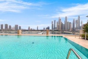 A swimming pool with a city skyline in the background.