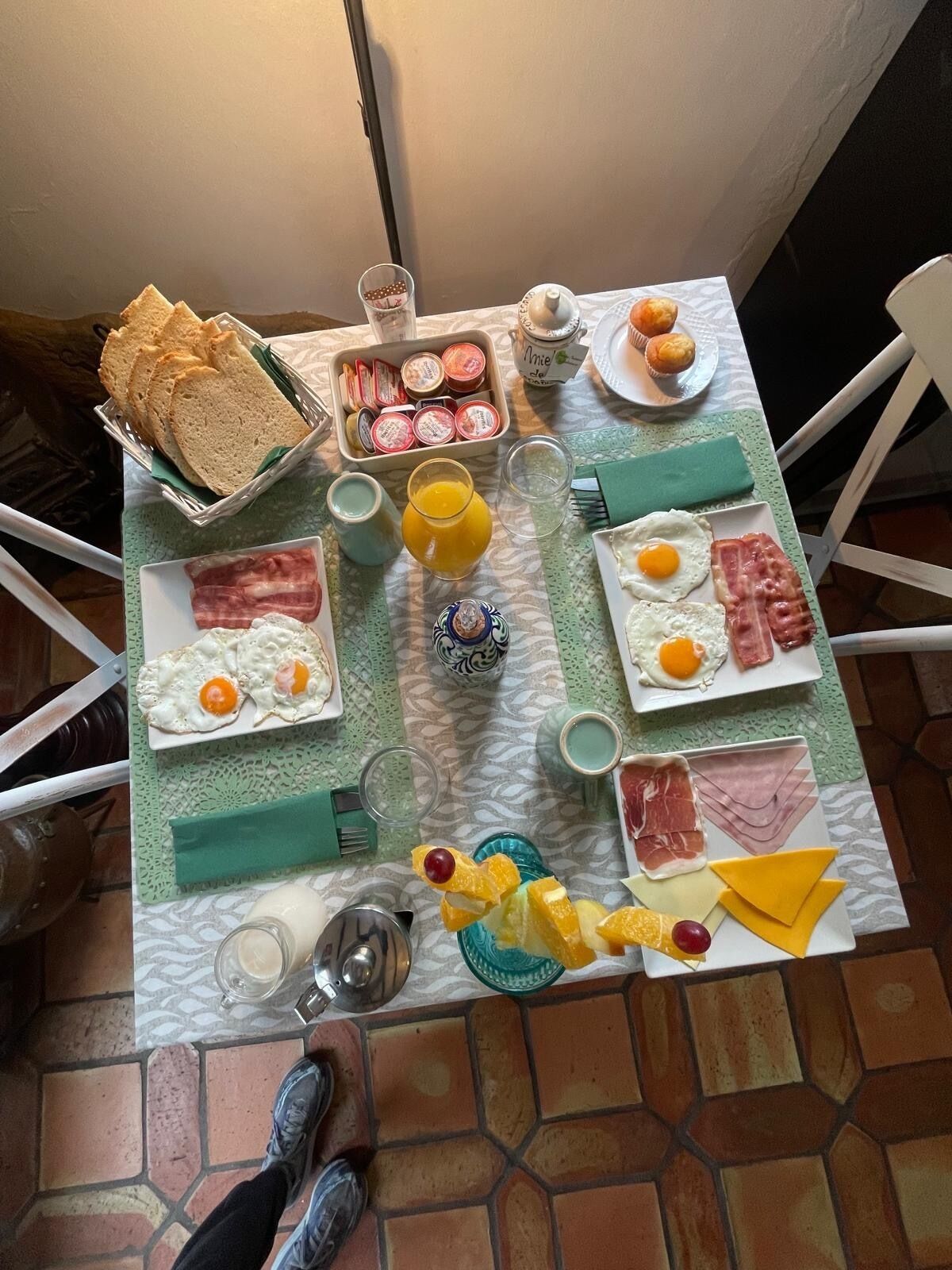 Une table de petit-déjeuner avec divers aliments et condiments.