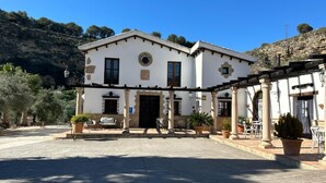 A two-story building with a central entrance, columns, and outdoor seating. - Hotel Rural La Hacienda de Ronda  (Ronda)