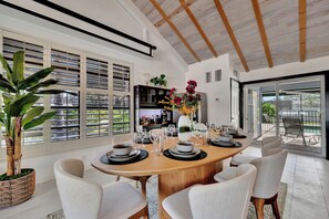 Comedor con mesa de madera dispuesta para seis personas, rodeada por seis sillas.
