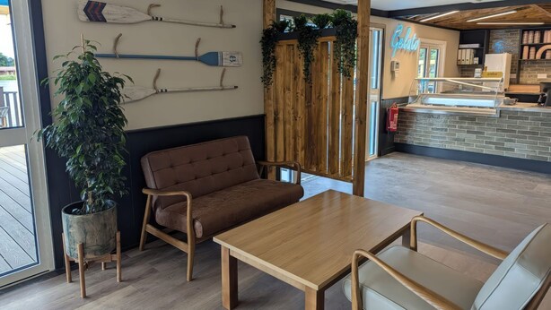 Een modern interieur met een houten tafel en stoelen, een potplant en een muur versierd met decoratieve paddles.