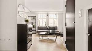Una sala moderna con sofá, mesa de centro y estanterías.