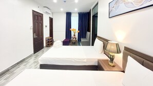 Een hotelkamer met een bed, nachtkastje, lamp en kunst aan de muur.