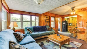 A cozy living room with a blue sofa, wooden coffee table, and a patterned rug.