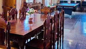 A spacious dining area with a long wooden table, multiple chairs, and a pool table. - Chateau La Princesa with lovely garden & bar "family friendly villa" (Puerto Princesa City)