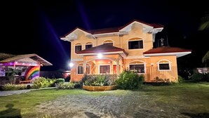 A two-story house with a red roof and a porch. - Chateau La Princesa with lovely garden & bar "family friendly villa" (Puerto Princesa City)