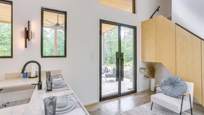 Eine moderne Küche mit Marmorarbeitsplatte, integriertem Spülbecken und Deckenventilator.