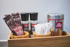 A wooden box containing various coffee products including a canister labeled 'illy' and several packets of coffee. - Großzügiges Apartment Nahe Frankfurt (Muhlheim am Main)