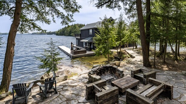 Un chalet au bord du lac, doté d’un quai, d’un espace salon extérieur et d’un foyer.