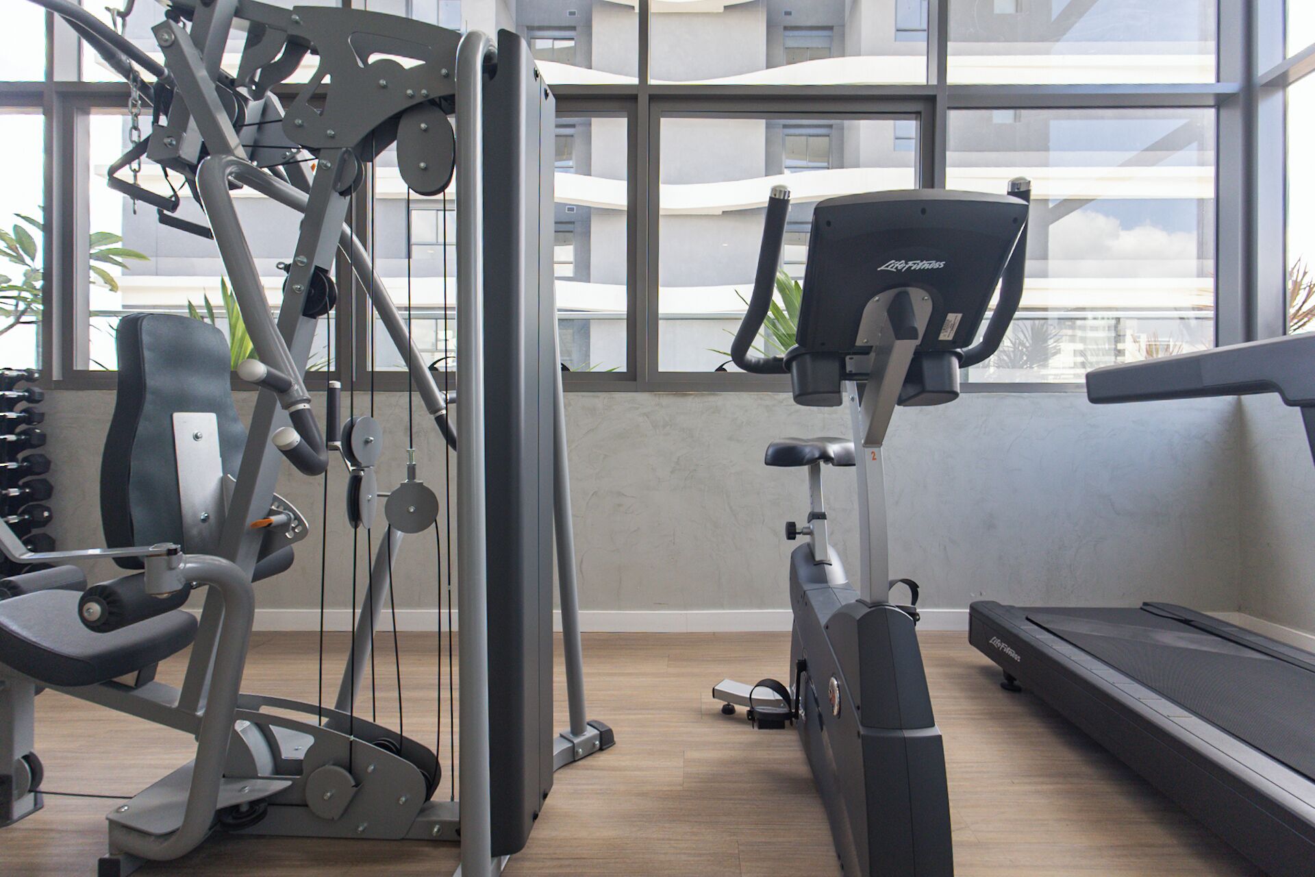 A gym with cardio equipment, a treadmill, and weight machines.