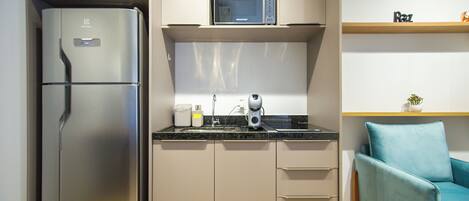 A compact kitchen with a refrigerator, microwave, and coffee maker.