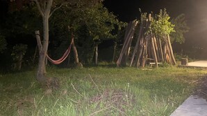 A nighttime outdoor area with a hammock, wooden structures, and a paved path. - House in the Vineyard (Ambrolauri)