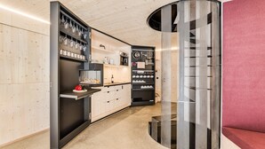 Een moderne keuken met inbouwapparatuur, een houten wand en een unieke geperforeerde kolom.