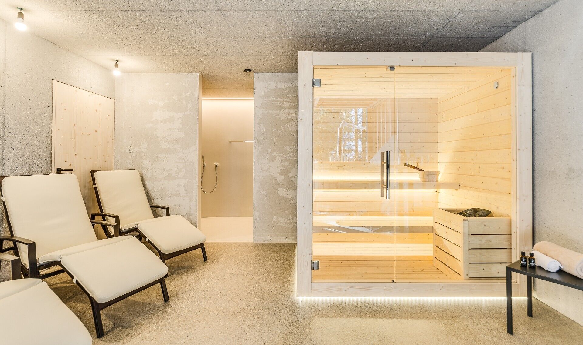 A spa room with wooden walls, a sauna, and seating areas.