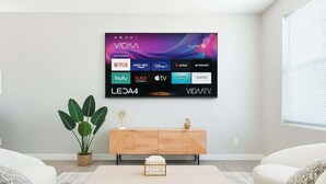 A modern living room with a flat-screen TV mounted on the wall displaying various streaming services. - 3BD / Free Parking / 75" Smart TV / 2BR / 2Bath (Glendale)