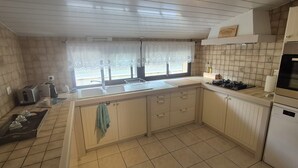 A kitchen with a gas stove, a sink, and a built-in oven.